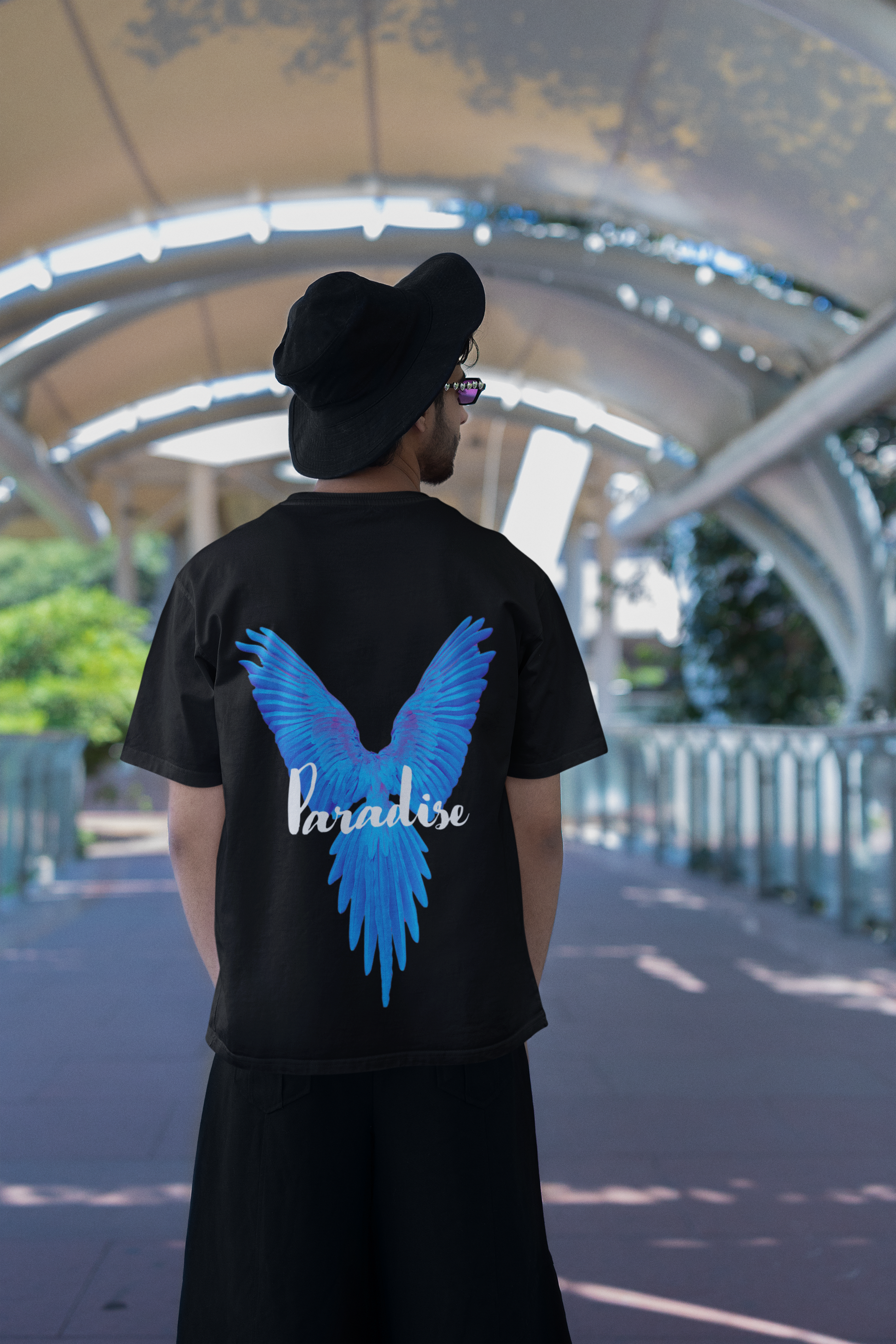 Model wearing W.I.F.I Men's Oversized "Paradise Blue Wings" Graphic T-Shirt in a casual setting